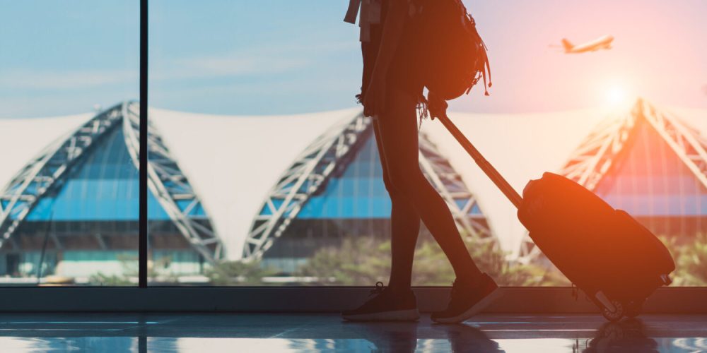 Silhouette,Woman,Travel,With,Luggage,Walking,Side,Window,At,Airport