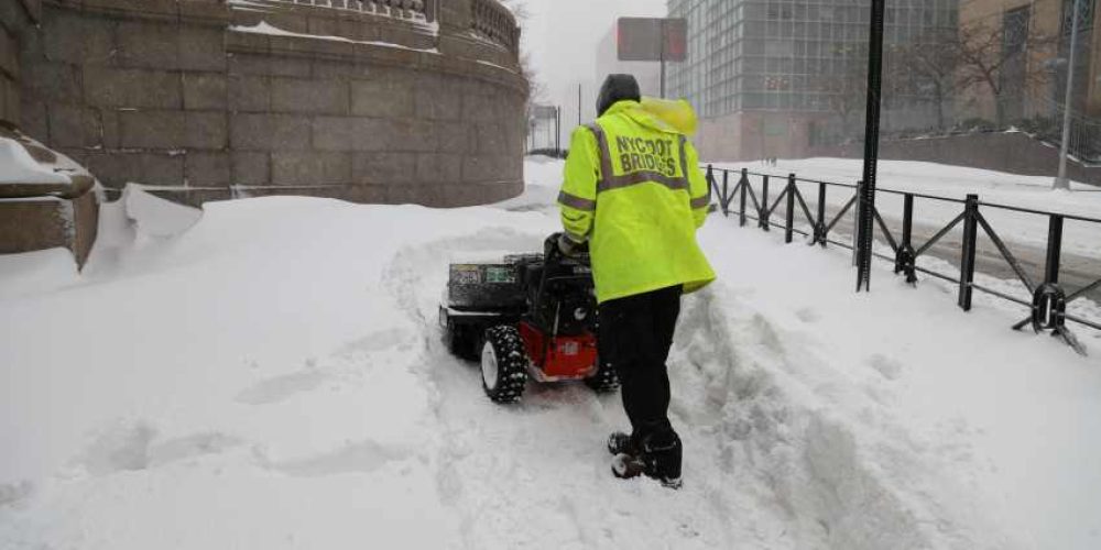 DOT Bridges team removes snow from Manhattan Bridge pedestrian path.

Photo: New York City Department of Transportation