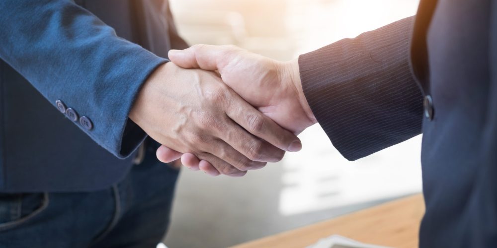 Two confident business man shaking hands during a meeting in the office, success, dealing, greeting and partner concept